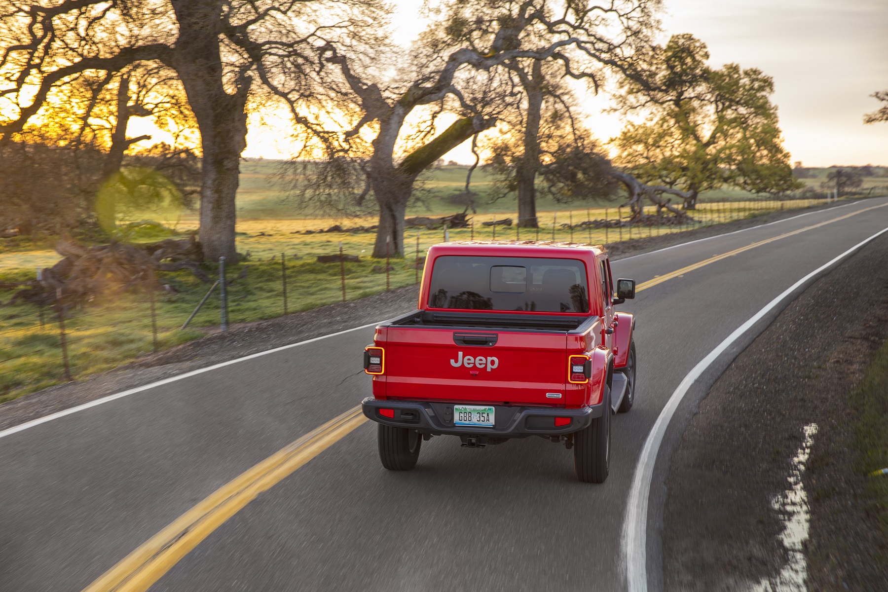 Jeep Gladiator Overlandha de traseira fazendo uma curva na estrada