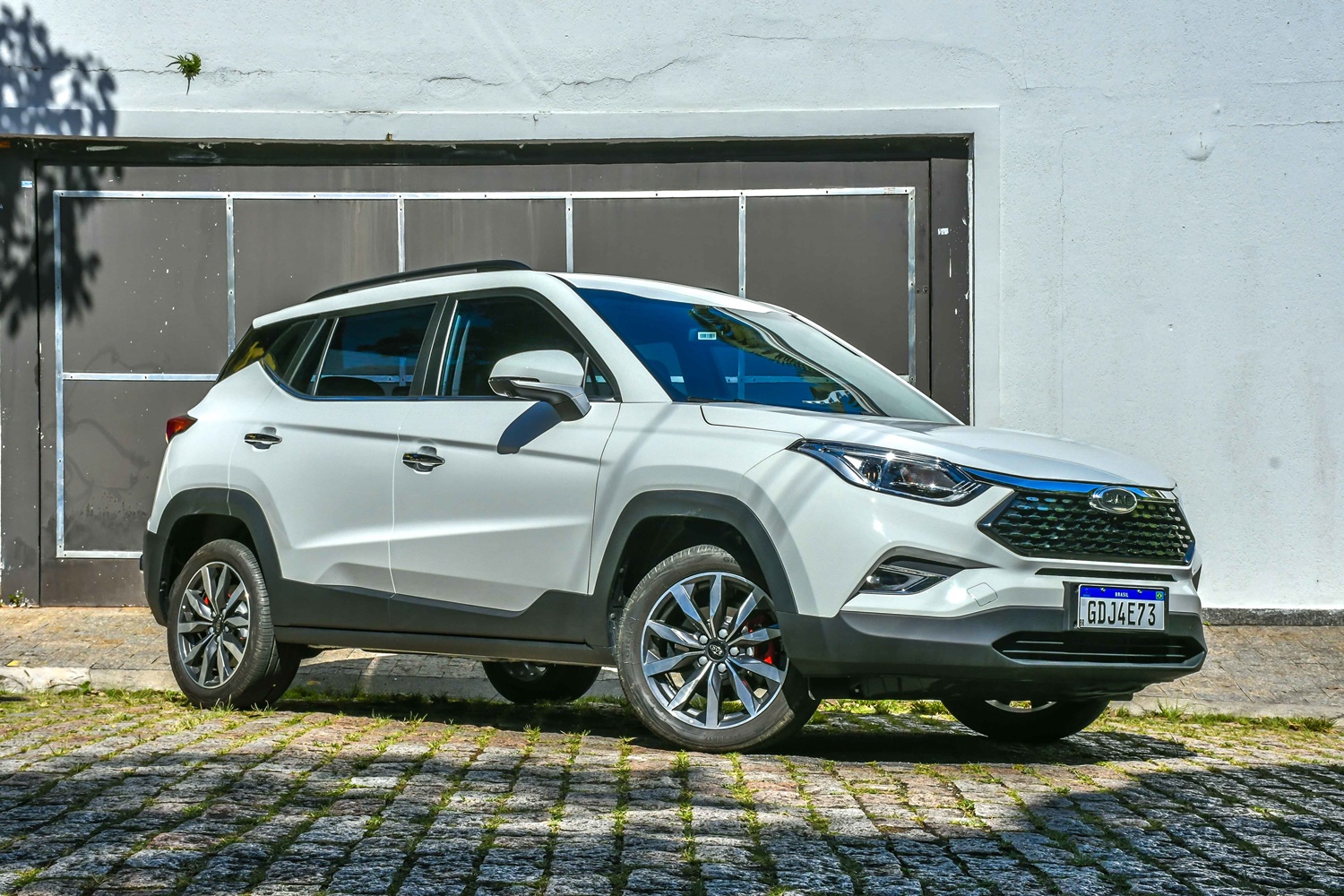 Jac T60 branco estacionado de frente ao fundo um galpão com muto cinza